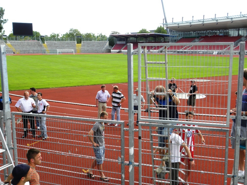 Trainerstab, Mannschaft und Fans bauen gemeinsam Zaunerhöhung in der Nordkurve ab