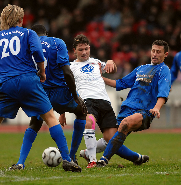 Skay Noutsos (mi.) gegen  Dubravko Kolinger, Lamine Cissé (li.)