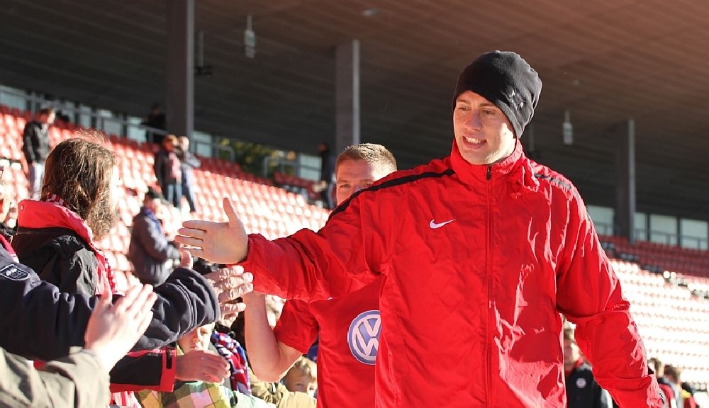 Henel beim Abklatschen mit den Fans
Im Hintergrund, Damm