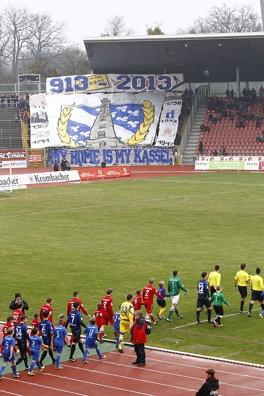 Auflaufen der Mannschaften, im Hintergrund die Choreo zum Stadtjubiläum